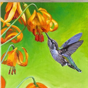 Puede incluir: Una pintura de un colibrí con plumas verdes y azules iridiscentes, flotando cerca de un grupo de flores de lirio naranja con tallos verdes sobre un fondo verde.