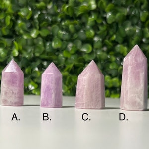 May include: Four pink and white crystal points labelled A, B, C, and D. The points are arranged in a row from left to right.
