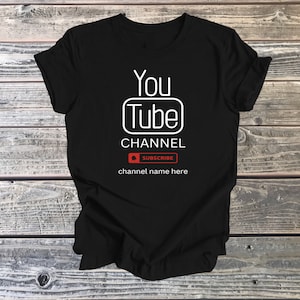 May include: Black t-shirt with a white graphic of the YouTube logo and the text "You Tube Channel" with a red button that says "Subscribe" and the text "channel name here" below.