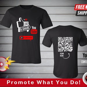 May include: Black t-shirt with a white thumbs up and the text "Like & Share You Tube" and a play button with the text "Subscribe". The back of the shirt has a black and white QR code with the text "Scan Here" and "You Tube Content Creators".