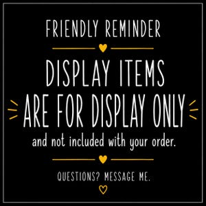 K&ouml;nnte beinhalten: Ein schwarzes quadratisches Schild mit wei&szlig;em Text: FRIENDLY REMINDER, DISPLAY ITEMS ARE FOR DISPLAY ONLY and not included with your order. QUESTIONS? MESSAGE ME. Der Text ist mit kleinen gelben Herzen und horizontalen Linien verziert.