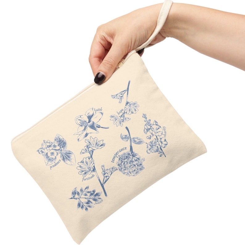 May include: A beige canvas zippered pouch with a blue floral design and the words "faith", "hope", "charity", "prudence", "fortitude", "temperance", "justice" printed on it.