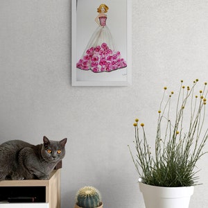 Pode incluir: Uma pintura em aquarela emoldurada de uma mulher em um vestido rosa e branco adornado com rosas cor-de-rosa. Um gato cinza com olhos amarelos est&aacute; sentado em um arm&aacute;rio de madeira. Um cacto em uma cesta e uma planta em vaso tamb&eacute;m s&atilde;o vis&iacute;veis.