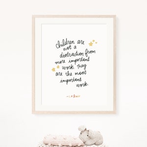 May include: A framed print with a white background and black text that reads "Children are not a distraction from more important work. They are the most important work. - C.S. Lewis". The text is surrounded by gold stars.