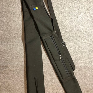 May include: Black canvas carrying case with a zippered pocket and adjustable shoulder strap. A small blue and yellow patch is sewn on the case.
