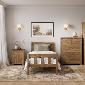 May include: A bedroom scene with a wooden bed, bedside table, and chest of drawers. The bed has a white duvet and a beige pillow. A framed landscape picture hangs above the bed. The room has a neutral colour scheme with a patterned rug.