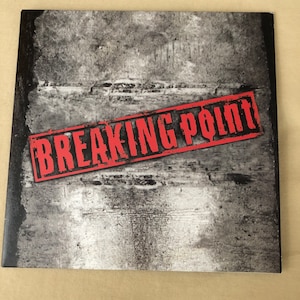May include: A black and white image of a textured surface with the words "BREAKING POINT" in red letters stamped across the image.