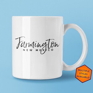 May include: White ceramic mug with a black handwritten design that says "Farmington New Mexico".