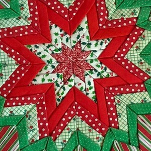 Op de afbeelding: Een stervormig quiltblok in rood en groen met een hulstpatroon. Het quiltblok is gemaakt van stofresten die in een geometrisch patroon aan elkaar zijn genaaid.