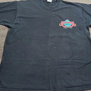 May include: Black t-shirt with a red and blue logo that says "Alamo Grill" with the words "Tucson, Arizona" underneath.