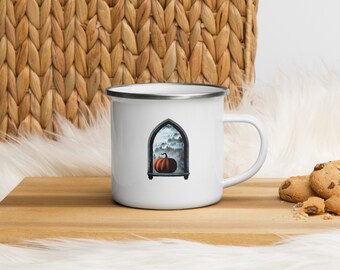May include: White enamel mug with a black rim and handle. The mug features a graphic of a pumpkin in a stone archway with a foggy forest behind it.