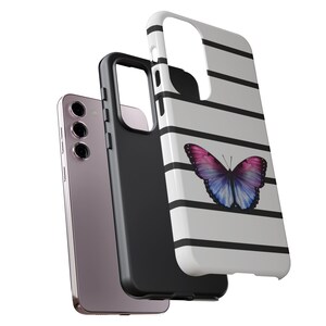 K&ouml;nnte beinhalten: Eine schwarz-wei&szlig; gestreifte Handyh&uuml;lle mit einem lila und blauen Schmetterlingsdesign. Die H&uuml;lle wird mit einem Telefon darin gezeigt.