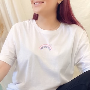 May include: White t-shirt with a multi-colored rainbow graphic on the front.