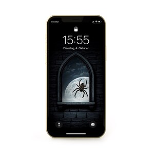 Puede incluir: Un teléfono inteligente con una pantalla negra que muestra un reloj digital que marca las 15:55 y la fecha Dienstag, 4. Oktober. La imagen de fondo es una ventana gótica oscura con una telaraña y una araña en una luna llena.