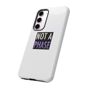 May include: White phone case with a black square that says "NOT A PHASE" in yellow, purple, and white text.