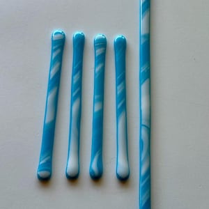 May include: Five glass rods with a blue and white swirl pattern. The rods are arranged vertically in a row, with the longest rod on the right.