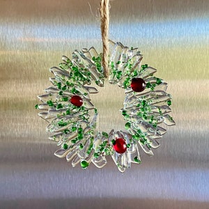 Fused glass ornament in clear glass with sprinkle of green glass and red berries