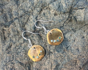 Un magnifique ensemble de boucles d'oreilles en bronze incrusté de minuscules morceaux de plastique marin recyclé sur un collier en argent sterling 100 % recyclé taillé en diamant.