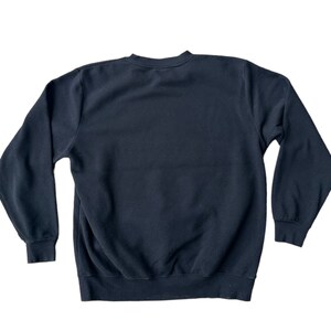 May include: A black crew neck sweatshirt with long sleeves.