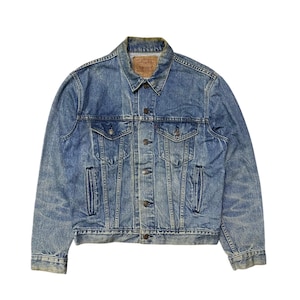 May include: A classic blue denim jacket with a button-up front, two chest pockets, and side pockets. The jacket features a faded wash and a small brown label on the collar. The jacket is a timeless piece of outerwear.