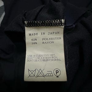 K&ouml;nnte beinhalten: Nahaufnahme eines Etiketts mit der Aufschrift "MADE IN JAPAN", Stoffzusammensetzung: 62% Polyester, 38% Rayon. Pflegehinweise: Reinigungsnetz verwenden, kein Dampfb&uuml;geleisen, nicht im Trockner trocknen.