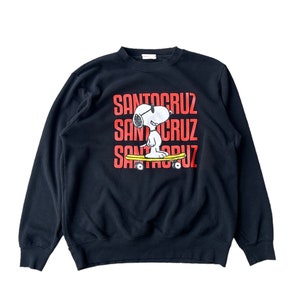 May include: Black sweatshirt with a red and white graphic of Snoopy skateboarding and the text "Santa Cruz" repeated three times.