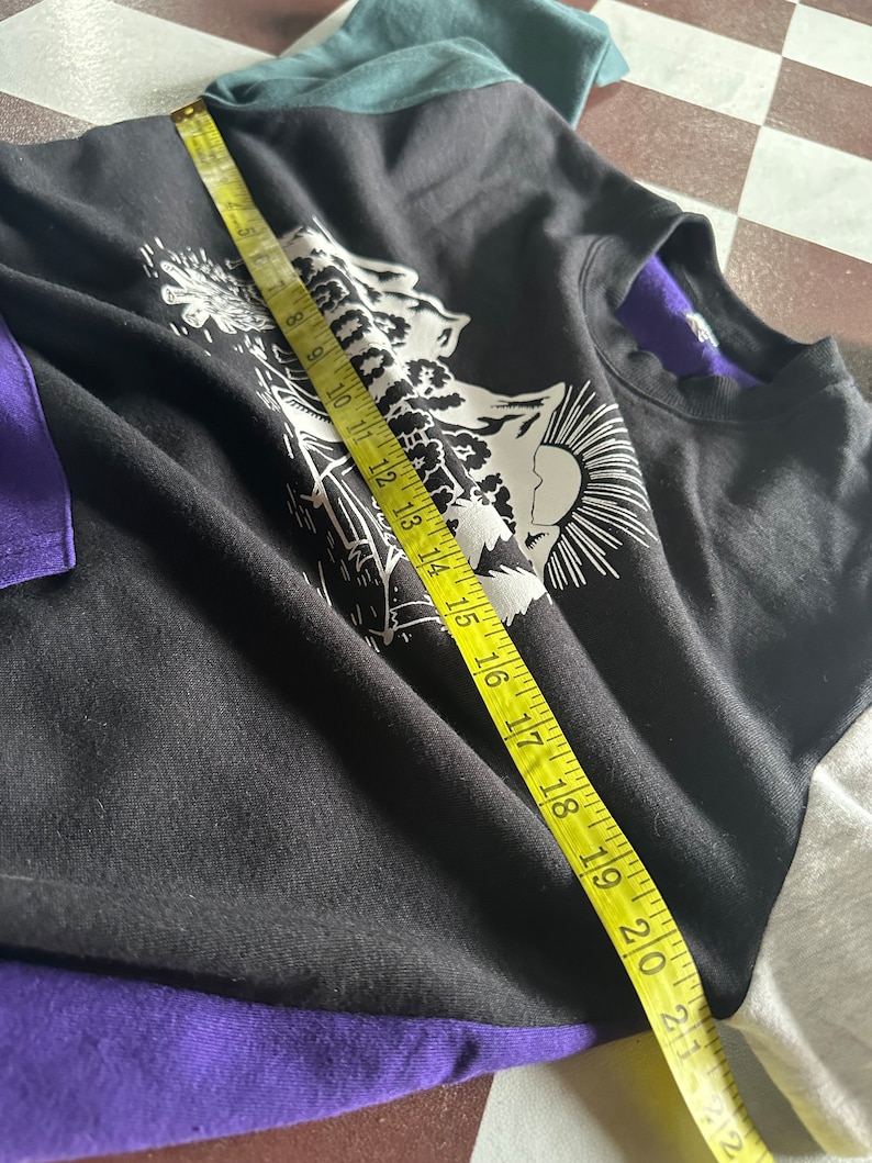 Puede incluir: Camiseta de manga larga negra, morada, azul verdoso y blanca con un estampado gr&aacute;fico de una escena de monta&ntilde;a y el texto "Mountain High".