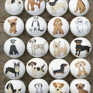 May include: A collection of twenty white wooden knobs, each featuring a different hand-painted dog breed illustration. The dogs are depicted in various poses and colors, including a Dalmatian, a Husky, and a Dachshund. These knobs are ideal for adding a unique touch to furniture.