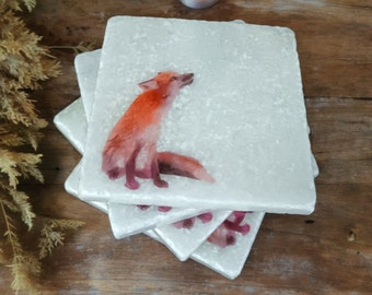 Puede incluir: Conjunto de cuatro posavasos de cerámica blanca con una ilustración de acuarela de un zorro rojo en el posavasos superior. Los posavasos están apilados uno encima del otro.
