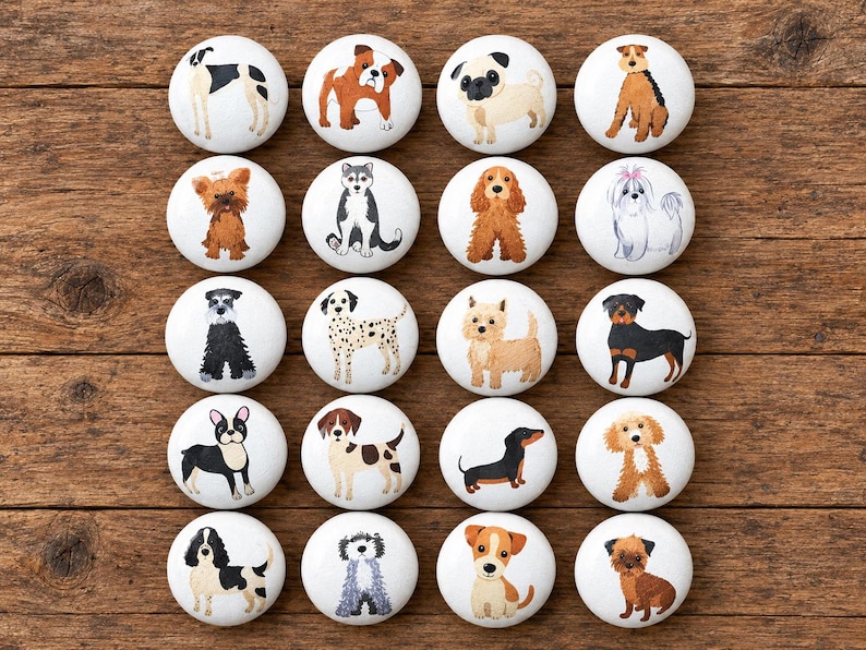 May include: A set of twenty round white ceramic knobs, each featuring a unique hand-painted illustration of a different dog breed, including pugs, bulldogs, dalmatians, and dachshunds, arranged in a grid of five rows and four columns.