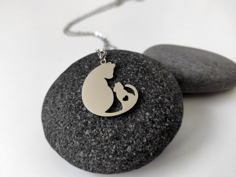 Necklace with a pendant of a cat mother and her baby. The necklace is delicate and feminine, and it would make a great gift for a cat lover.