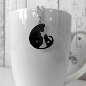 Necklace with a pendant of a cat mother and her baby. The necklace is delicate and feminine, and it would make a great gift for a cat lover.