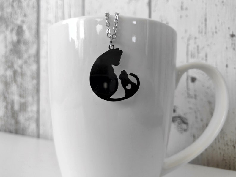 Necklace with a pendant of a cat mother and her baby. The necklace is delicate and feminine, and it would make a great gift for a cat lover.