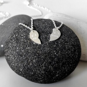 A close-up of the two necklaces with a dangling silver heart pendant. The necklace is perfect for best friends and symbolizes their unbreakable bond.