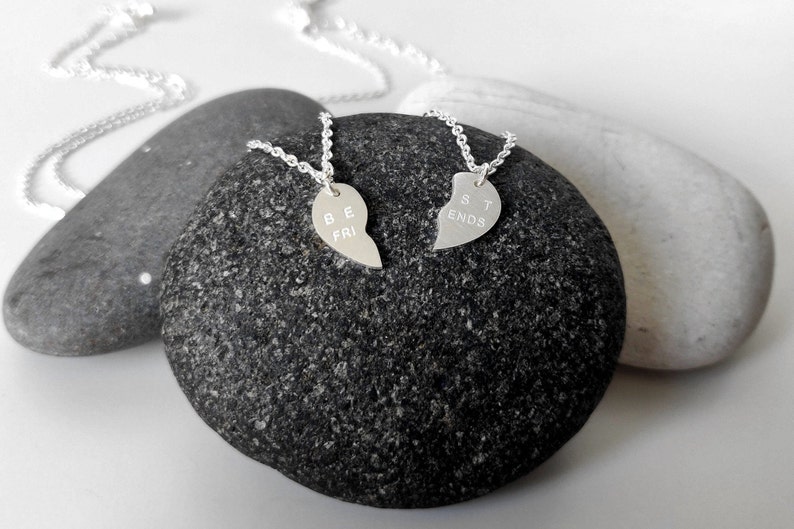 A close-up of the two necklaces with a dangling silver heart pendant. The necklace is perfect for best friends and symbolizes their unbreakable bond.
