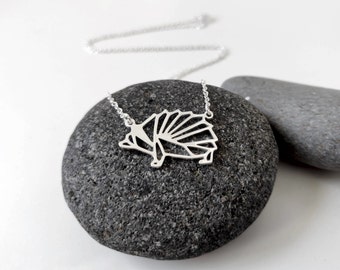 Peut inclure: Un collier en argent avec un pendentif en forme de hérisson géométrique. Le pendentif est fait d'un métal fin et présente un design détaillé.
