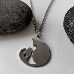 Necklace with a pendant of a cat mother and her baby. The necklace is delicate and feminine, and it would make a great gift for a cat lover.