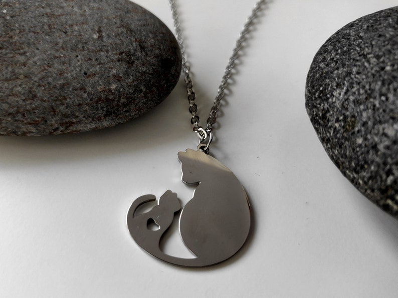 Necklace with a pendant of a cat mother and her baby. The necklace is delicate and feminine, and it would make a great gift for a cat lover.