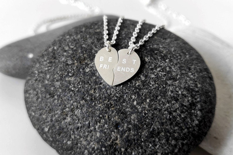 A close-up of the two necklaces with a dangling silver heart pendant. The necklace is perfect for best friends and symbolizes their unbreakable bond.