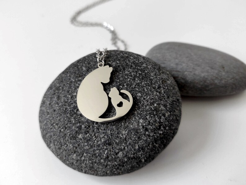 Necklace with a pendant of a cat mother and her baby. The necklace is delicate and feminine, and it would make a great gift for a cat lover.