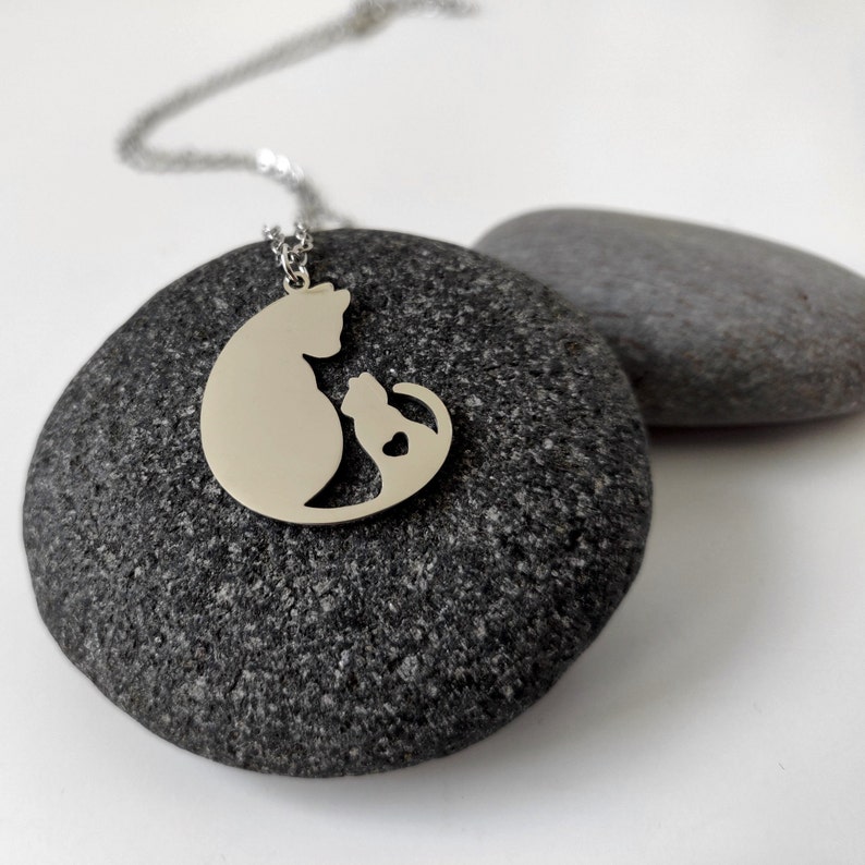 Necklace with a pendant of a cat mother and her baby. The necklace is delicate and feminine, and it would make a great gift for a cat lover.