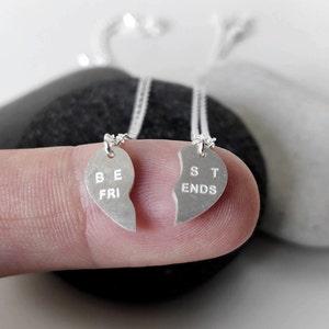 A close-up of the two necklaces with a dangling silver heart pendant. The necklace is perfect for best friends and symbolizes their unbreakable bond.
