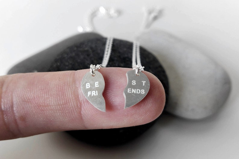 A close-up of the two necklaces with a dangling silver heart pendant. The necklace is perfect for best friends and symbolizes their unbreakable bond.