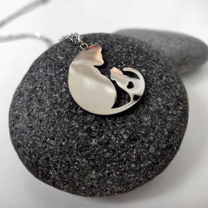 Necklace with a pendant of a cat mother and her baby. The necklace is delicate and feminine, and it would make a great gift for a cat lover.