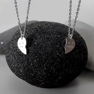 A close-up of the two necklaces with a dangling silver heart pendant. The necklace is perfect for best friends and symbolizes their unbreakable bond.