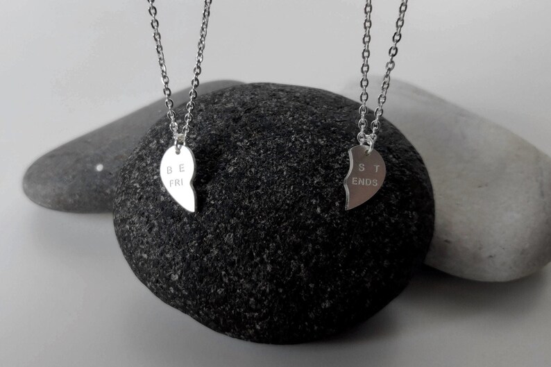 A close-up of the two necklaces with a dangling silver heart pendant. The necklace is perfect for best friends and symbolizes their unbreakable bond.