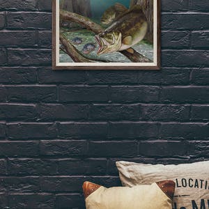 May include: A framed illustration of a largemouth bass with its mouth open, as if it is about to eat a smaller fish. The bass is swimming in a murky green water with a log in the foreground. There are several smaller fish swimming around the bass.