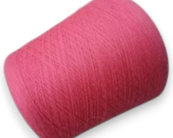 Puede incluir: Una bobina cilíndrica de hilo de color rosa intenso, enrollada firmemente con una textura entrecruzada visible en toda la superficie. El hilo se presenta como una unidad única de color sólido con un patrón de bobinado denso.