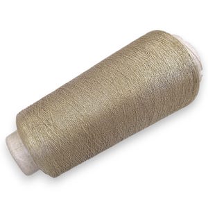 Puede incluir: Una bobina de hilo de color oro claro. El hilo está enrollado firmemente alrededor de un núcleo de cartón, creando una forma cilíndrica. El hilo tiene un brillo sutil, lo que sugiere una mezcla de materiales. Ideal para coser, bordar u otras manualidades textiles.