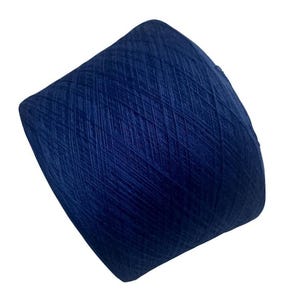 May include: A large cone of navy blue yarn, tightly wound and set against a white background. The yarn has a deep, solid blue colour and a soft, textured appearance. Ideal for knitting or crochet projects, the yarn's texture is clearly visible.